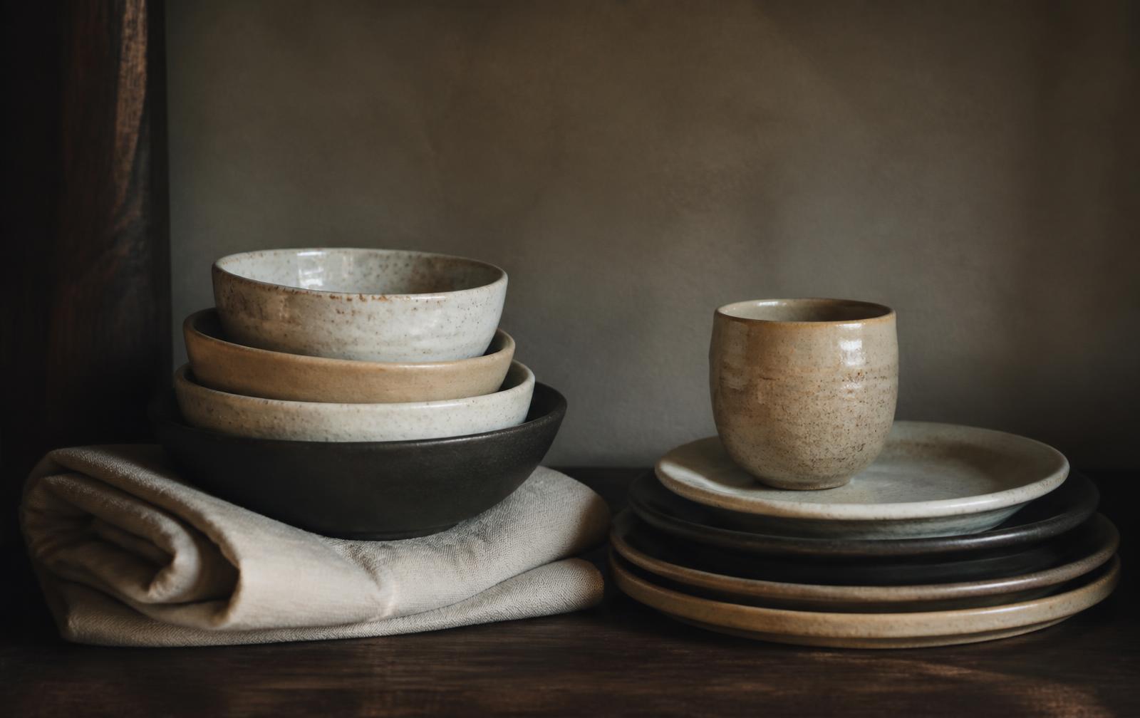 Handmade Korean ceramics stacked beside folded linen